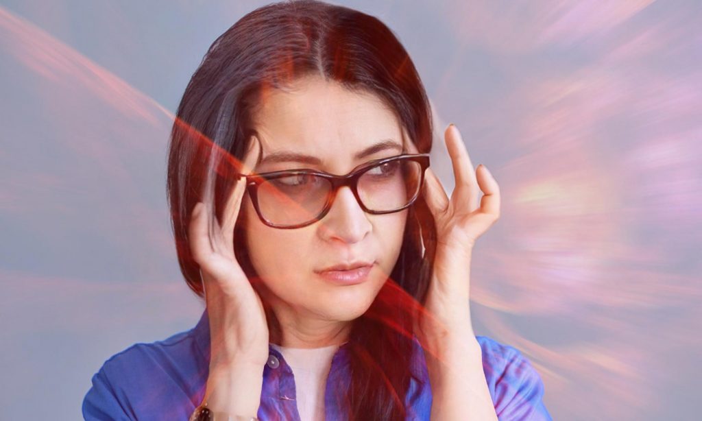 Женщина испытывает зрительные галлюцинации "фосфены" во время приступа мигрени с аурой