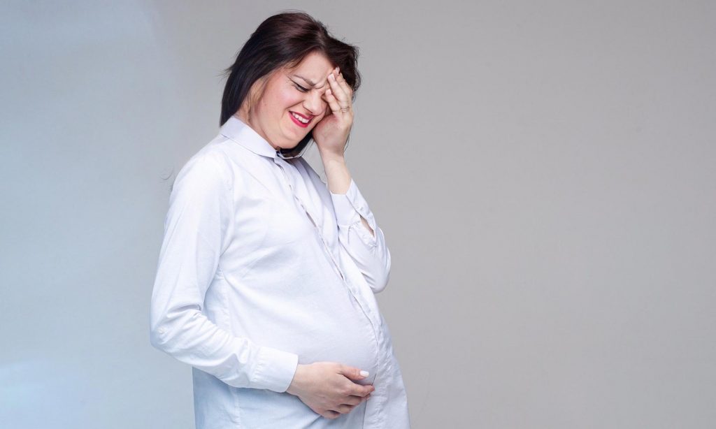 Беременная женщина испытывает сильную головную боль